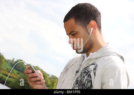 Profi-Fußballer Ben Fairclough anhören von Musik auf einen Ipod MP3-Player. Stockfoto