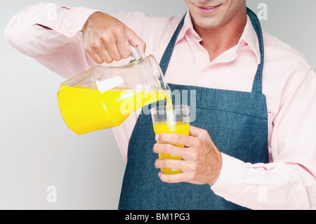 Mann, o-Saft in ein Glas gießen Stockfoto