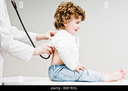 Ärztin untersucht einen kleinen Jungen mit einem Stethoskop Stockfoto