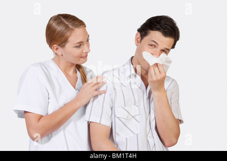 Frau neben einem Mann leidet unter Kälte Stockfoto