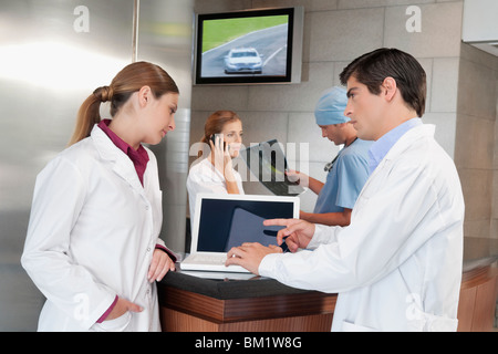 Zwei Ärzte diskutieren während mit einem laptop Stockfoto