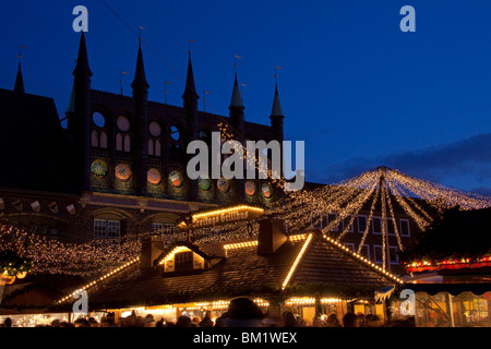 Illuminationen und Stände auf dem Weihnachtsmarkt auf dem Marktplatz vor dem Rathaus, Lübeck, Deutschland Stockfoto