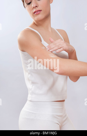Frau, die Anwendung der Feuchtigkeitscreme Creme auf dem arm Stockfoto