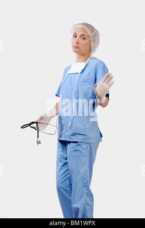 Weibliche Chirurg hält ein Stethoskop und Gestikulieren Stockfoto