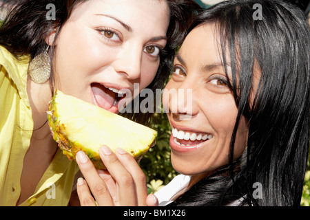Porträt zweier Frauen Essen ein Stück Ananas Stockfoto