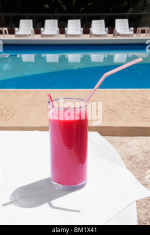 Glas Fruchtsaft am Pool Stockfoto