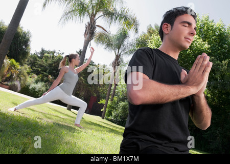 Paar praktizieren Yoga in einem park Stockfoto