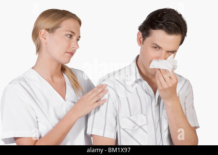 Frau neben einem Mann leidet unter Kälte Stockfoto