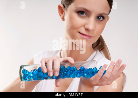 Frau, Gießen Badeperlen auf ihrer Handfläche Stockfoto