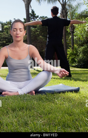 Paar praktizieren Yoga in einem park Stockfoto