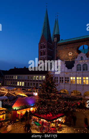 Illuminationen und Stände auf dem Weihnachtsmarkt auf dem Marktplatz vor dem Rathaus, Lübeck, Deutschland Stockfoto