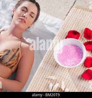Frau mit Aroma-Produkte neben ihr am Pool ausruhen Stockfoto