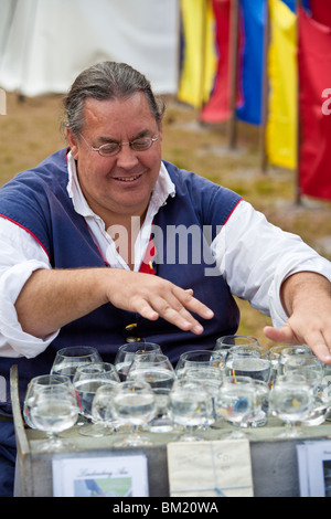 Gainesville, FL - Januar 2009 - Mann gekleidet in Periode, die Kleidung Musik auf Kristallgläser mit Wasser gefüllt spielt Stockfoto