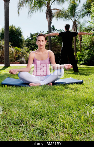 Paar praktizieren Yoga in einem park Stockfoto