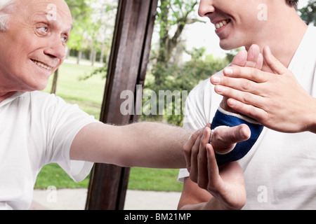 Physiotherapeut untersucht die Hand eines Mannes Stockfoto