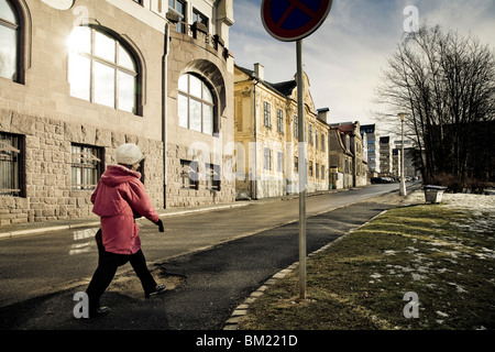 Eine Frau in einem roten Mantel geht oben B. Nemcove Street, Liberec, Tschechische Republik Stockfoto