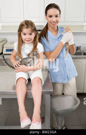 Weibliche Tierarzt mit einem Mädchen mit Katzen Stockfoto