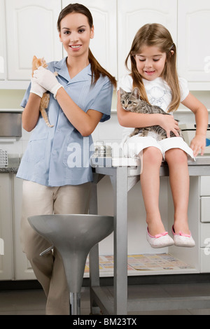 Weibliche Tierarzt mit einem Mädchen mit Katzen Stockfoto