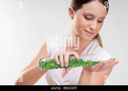 Frau, Gießen Badeperlen auf ihrer Handfläche Stockfoto