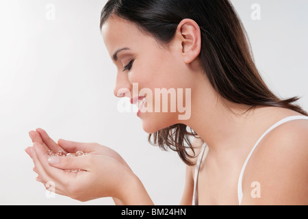 Frau riechen Badeperlen und lächelnd Stockfoto