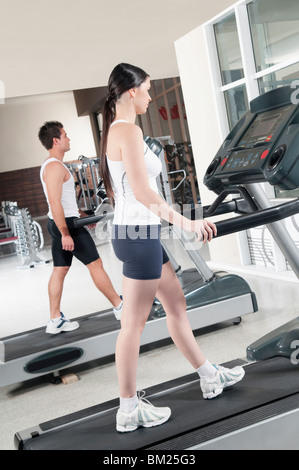 Frau und ein Mann zu Fuß auf Laufbändern Stockfoto