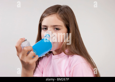 Mädchen mit einem Asthma-Inhalator mit einem Abstandshalter befestigt Stockfoto