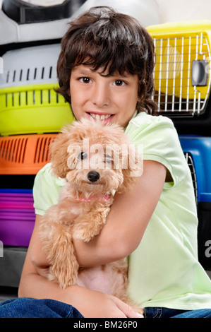 Jungen tragen einen Welpen in einem Supermarkt Stockfoto