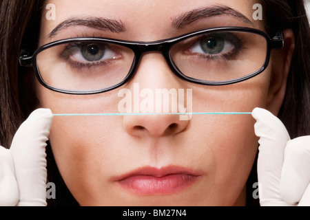 Nahaufnahme von einer Zahnärztin mit Zahnseide Stockfoto