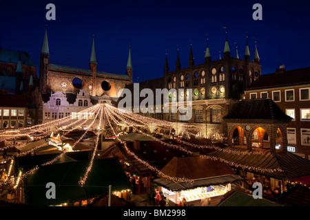 Illuminationen und Stände auf dem Weihnachtsmarkt auf dem Marktplatz vor dem Rathaus, Lübeck, Deutschland Stockfoto