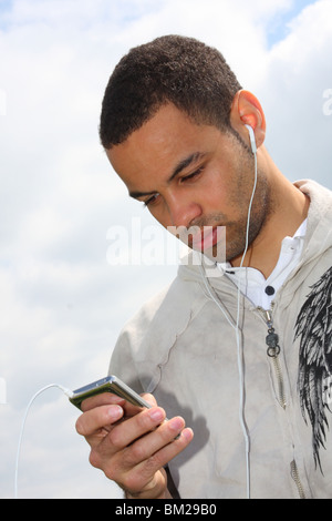 Profi-Fußballer Ben Fairclough anhören von Musik auf einen Ipod MP3-Player. Stockfoto