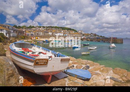 Kleines Boot am Kai und kleine Boote im geschlossenen Hafen von Mousehole, Cornwall, UK Stockfoto