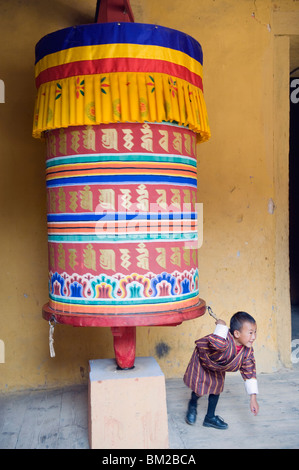 Kleiner Junge ziehen eine Gebetsmühle, Jakar Dzong, Schloss der weißen Vogel, Jakar, Bumthang, Chokor Valley, Bhutan Stockfoto