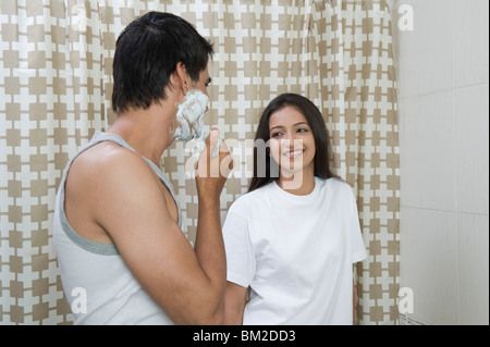 Rasur Mann und eine Frau lächelnd in das Badezimmer Stockfoto