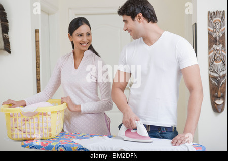 Mann mit einer Frau, die einen Wäschekorb Bügeln Stockfoto