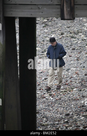 BEACHCOMBING, THE THAMES: Mann auf der Suche nach Sachen am Strand Thames South Bank Millennium Way Blackfriars London England Großbritannien Großbritannien Stockfoto