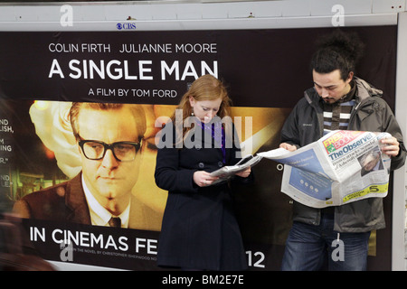 MENSCHEN IN DER U-BAHN KURZ VOR SMARTPHONES, 2010: London U-Bahn-Pendler Mann Frau junge Paare Leute lesen Observer Zeitung KEINE HANDYS Stockfoto