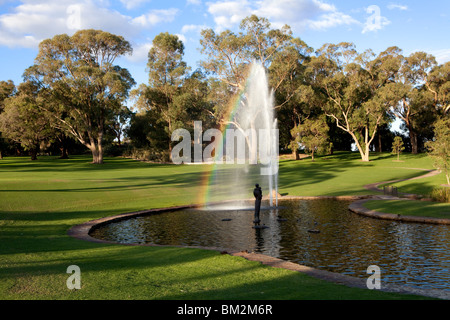 Brunnen und gepflegten Rasenflächen im Kings Park, Perth, Western Australia. Ein Regenbogen erscheint in den Brunnen Spray. Stockfoto