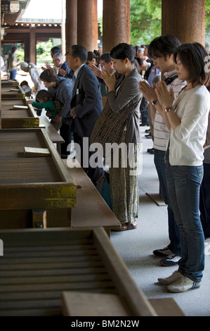 Gläubige beten vor Offertorium Kästen am main Hall von Meiji Jingu Schrein in Tokio, Japan Stockfoto