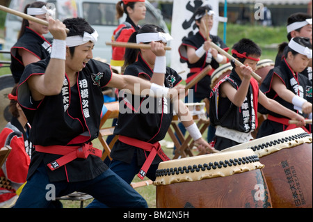 Energetische Gruppe von Trommlern, die japanischen Taiko-Trommeln während einer Outdoor-Performance, Japan Stockfoto