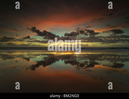 Twilight Farben der Wolken reflektieren über ein Ebbe Strand, Corrimal Beach, New South Wales Australien Stockfoto