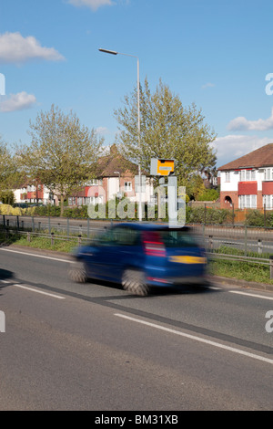 Ein blaues Auto, Beschleunigung vorbei einen Gatso Blitzer auf der A316 große Chertsey Road, Hounslow, UK. SIEHE BESCHREIBUNG Stockfoto