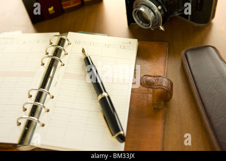 Tagebuch, Kugelschreiber, Bleistift und Kamera auf einem Schreibtisch Stockfoto
