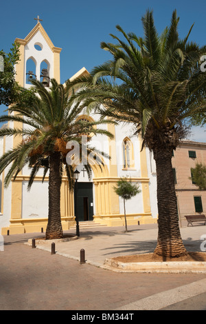 Detail der Kirche in Saint Climent, Menorca, mit Palmen im Vordergrund und gegen blauen Himmel Stockfoto