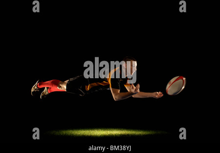 Rugby-Spieler Tauchen und Weitergabe Stockfoto