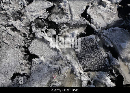 EISPACKUNG SCHWIMMENDES EIS AERIAL LAKE: Schnee Winter Schnee bedeckt gefrorenes Eis Schwimmer schwimmend gebrochener Riss aus nächster Nähe Kajaani Finnland Stockfoto