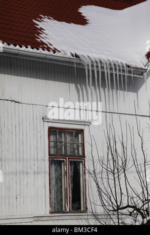 GROSSE EISZAPFEN AUF NORDISCHEM HAUS: Große Eiszapfen auf einem traditionellen Holzhaus in Godby auf dem Land Aland Archipel zwischen Finnland und Schweden Winter Stockfoto