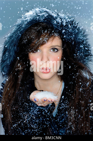 Porträt Frau bläst Schnee von hand Stockfoto