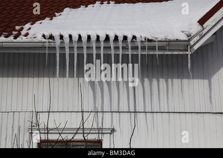 GROSSE EISZAPFEN AUF NORDISCHEM HAUS: Große Eiszapfen auf einem traditionellen Holzhaus in Godby auf dem Land Aland Archipel zwischen Finnland und Schweden Winter Stockfoto