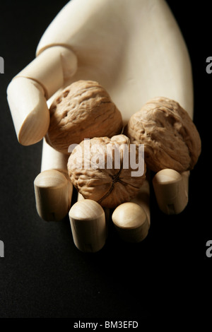 Puppe aus Holz Hand mit drei Walnüsse in offene hand Stockfoto