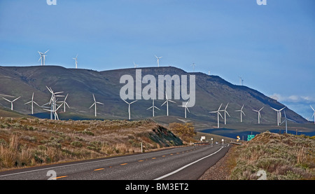 Dieses Landschaftsbild zeigt viele moderne weiße hoch Windmühle Stromerzeuger in Aktion drehen ihre Propeller entlang einer ländlichen. Stockfoto